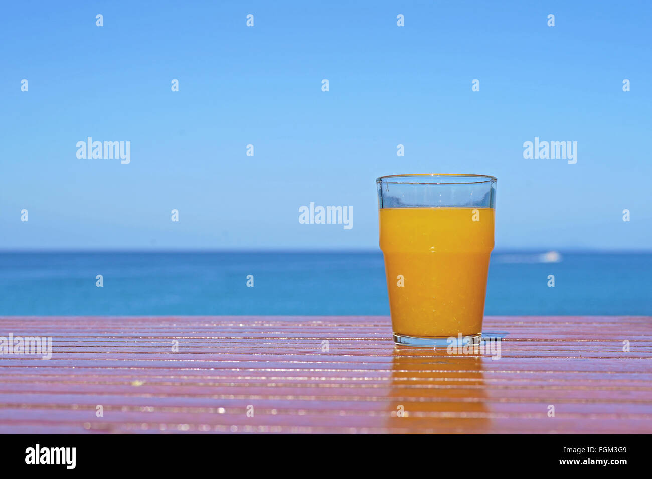 sweet orange juice on table with sea background Stock Photo