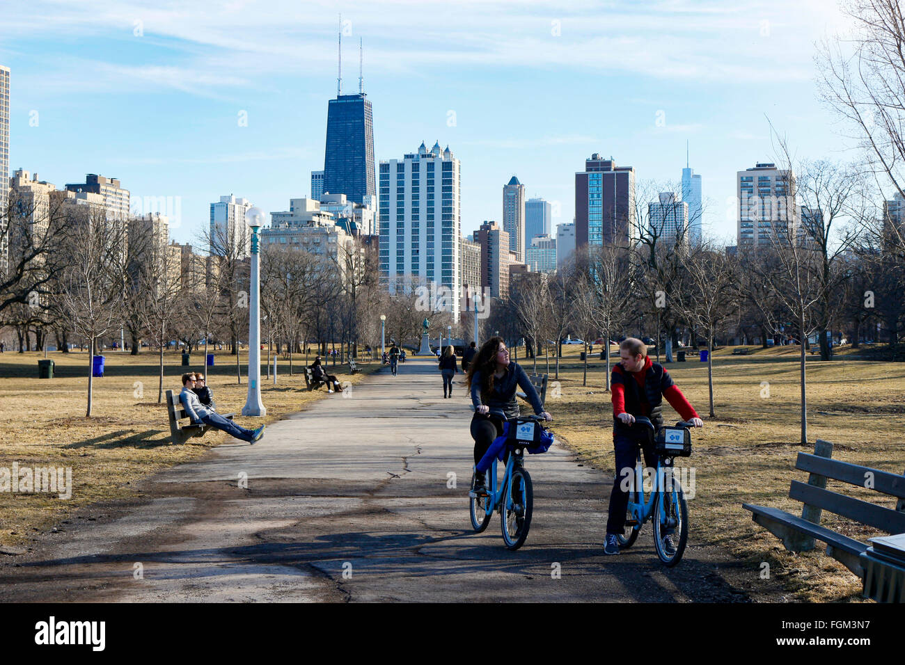 Chicago, USA 20th February 2016.  A young couple ride rental bikes through Lincoln Park. Chicagoans and visitors alike came to Lincoln Park and the lakeshore to enjoy an unseasonably warm day with temperatures over 60ºF/15ºC. The high winds that blasted the city yesterday subsided to a gentle breeze. Credit:  Todd Bannor/Alamy Live News Stock Photo
