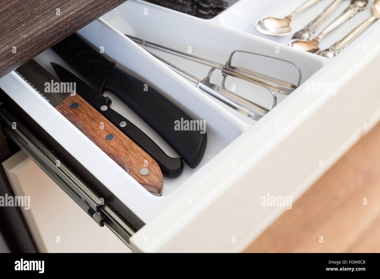 Spoons, forks and knives in cutlery box drawer in kitchen cupboard