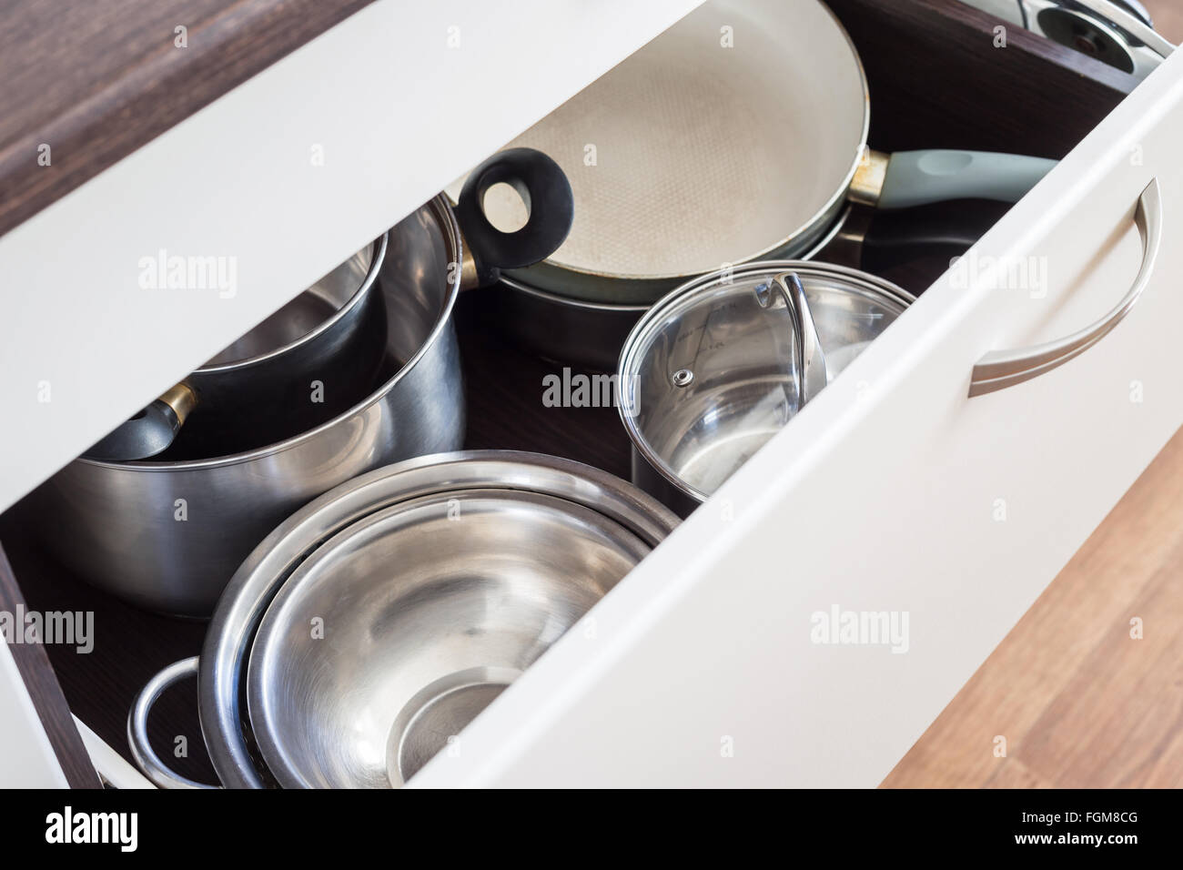 Open Drawer Of Cabinet With Steel Pots And Pans And Bowl Kitchen