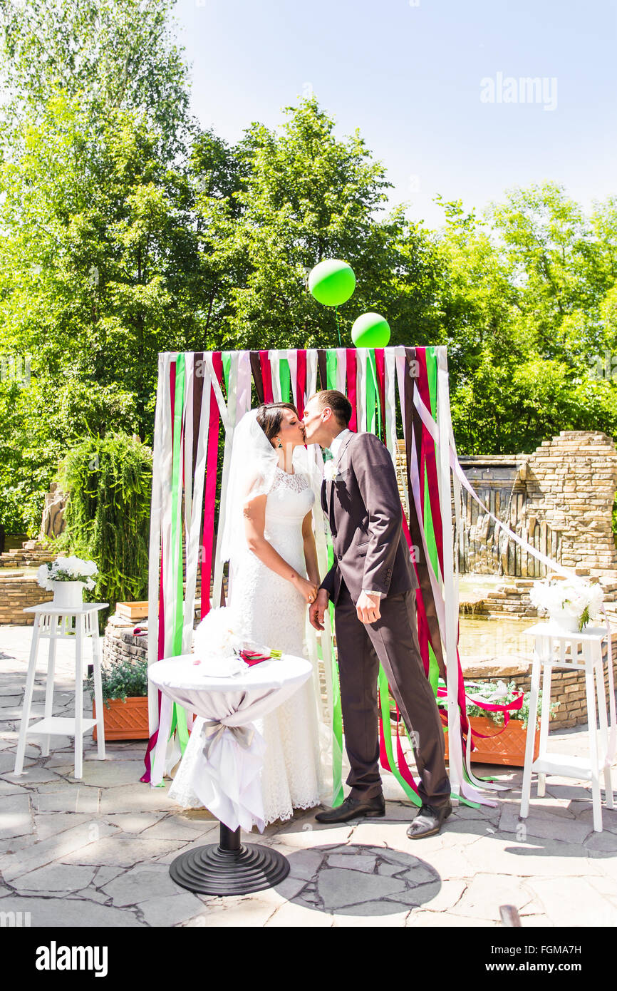 First kiss of newly married couple under wedding arch Stock Photo Alamy