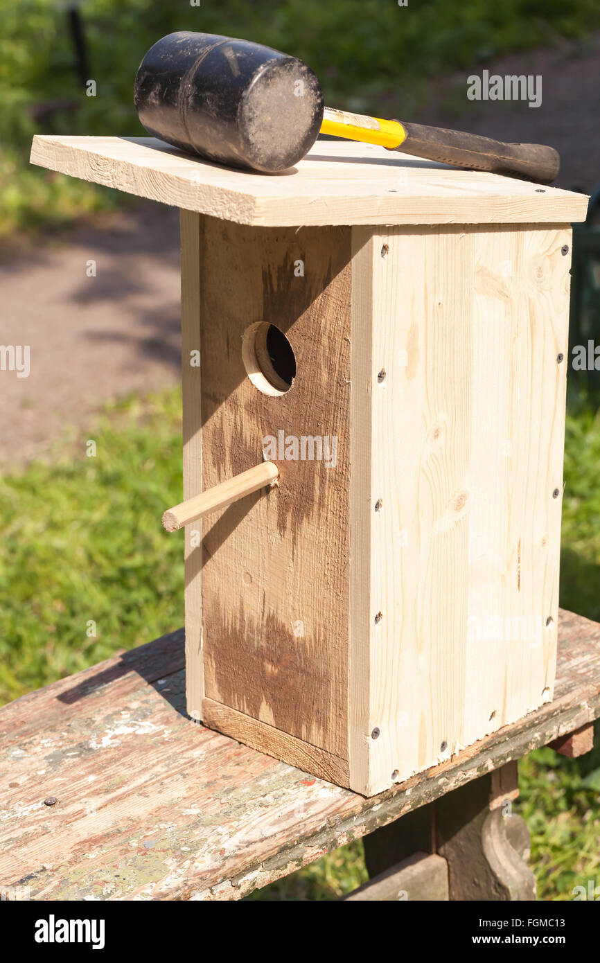 Rubber hummer lays on homemade birdhouse made of uncolored wood Stock Photo