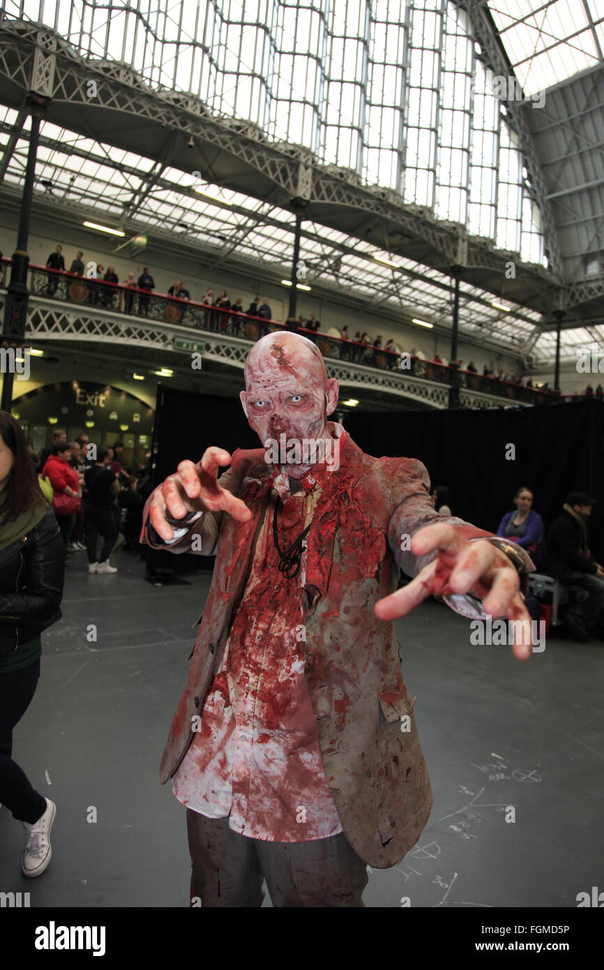 London, UK. 21st February, 2016. Walking Dead TV Convention Walker Stalker Con Olympia London 21/02/2016 walking dead fans gather to see stars of the show and stalls selling everything to do with the hit zombie American show photo ops with a star or zombie. cosplayers & undead walkers roaming the event floor entertaining the crowds. Stalls selling make-up and characters from the show. Credit:  Paul Thompson/Alamy Live News Stock Photo