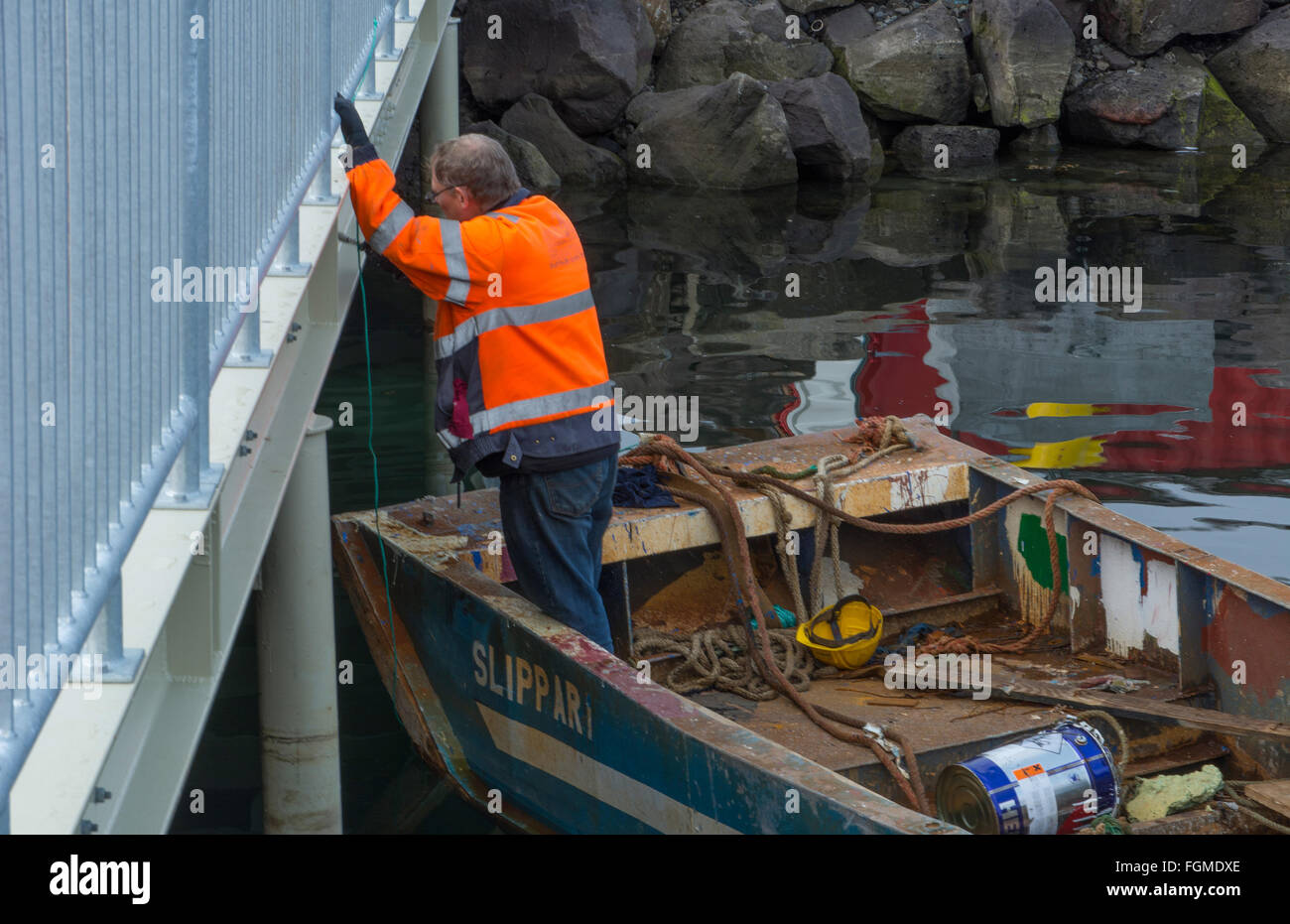 Reykjavik Iceland downtown Harbor man worker painter painting railing in marina port from boat