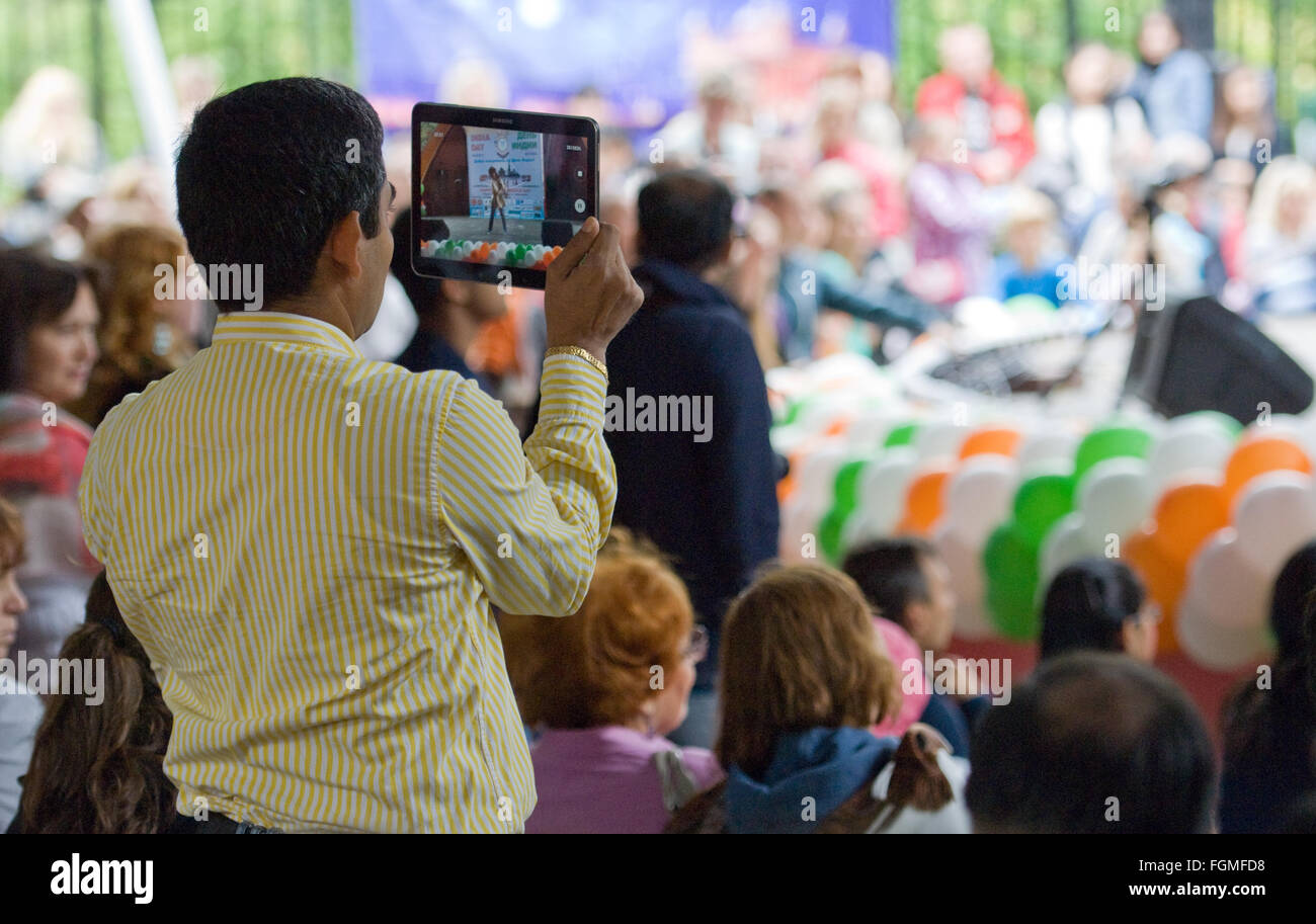 RUSSIA, MOSCOW - AUGUST 16, 2015: Unidentified indian man filming a dance of Center of India folk art on Independence Day of India in Sokolniki park, Moscow, Russia Stock Photo