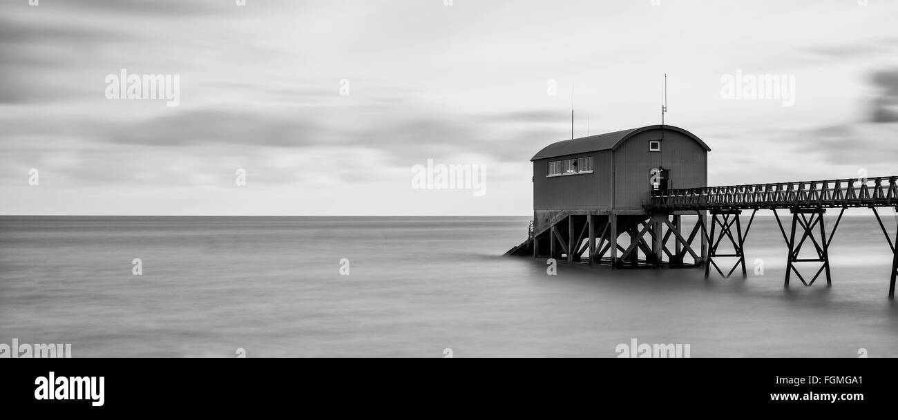 Beautiful long exposure landscape image of lifeboat jetty at sea Stock Photo