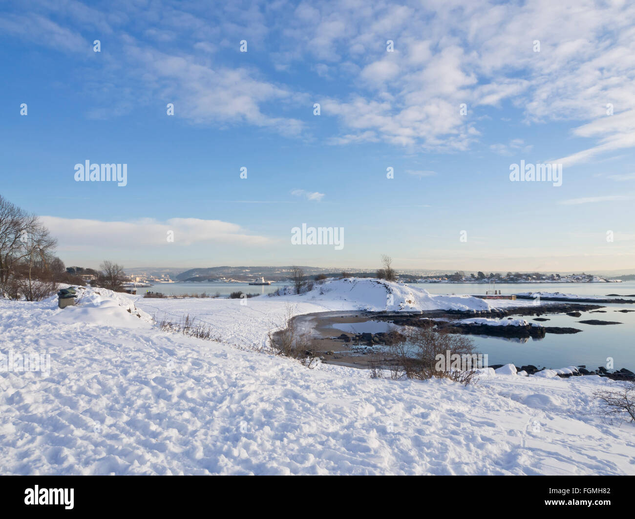 A winter day by the Oslo Fjord in Bygdøy Oslo Norway, low sun, snow and ice on rocks, footprints calm sea Stock Photo