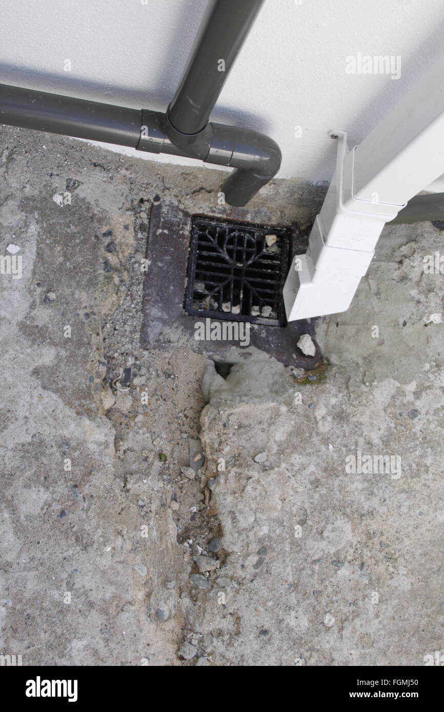 Badly repaired drain, crumbling cracked concrete and drain pipes Stock Photo