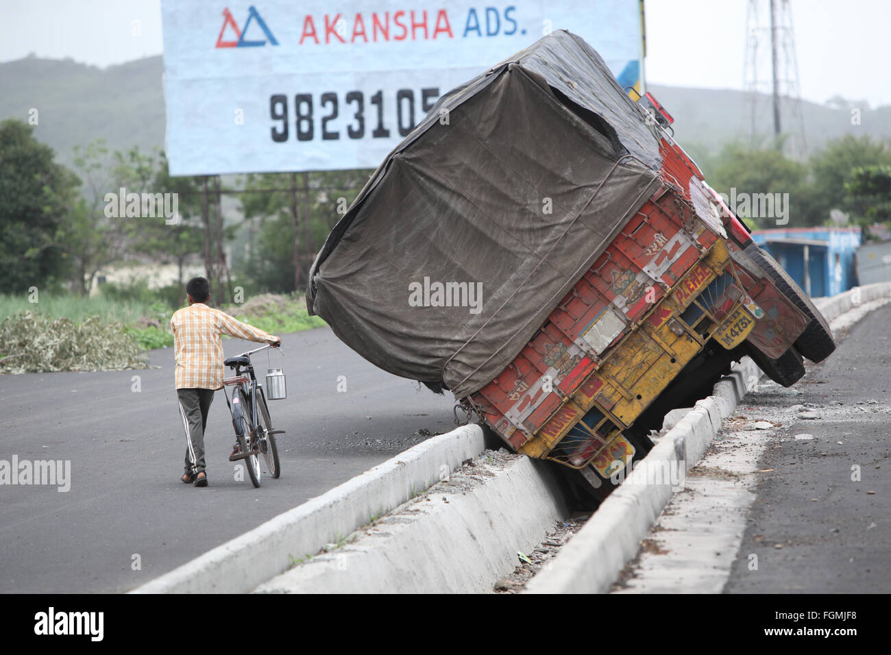 Pune, India - June 27, 2015: An truck that went out of control on an Indian highway and fell in storm drainage canal. Stock Photo