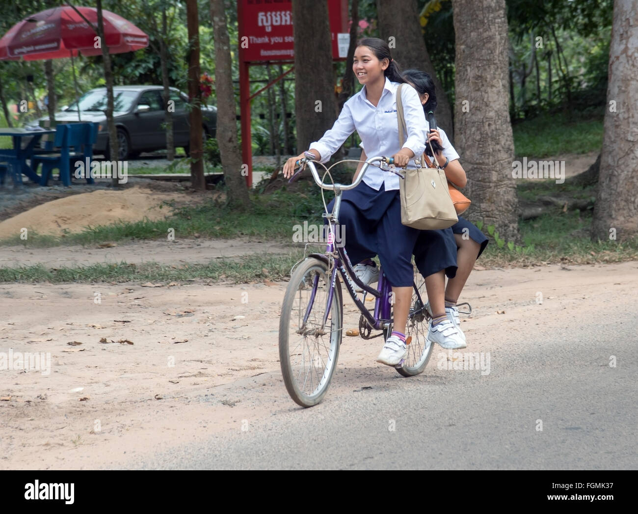 Cambodian schoolgirls ride on one bike Stock Photo