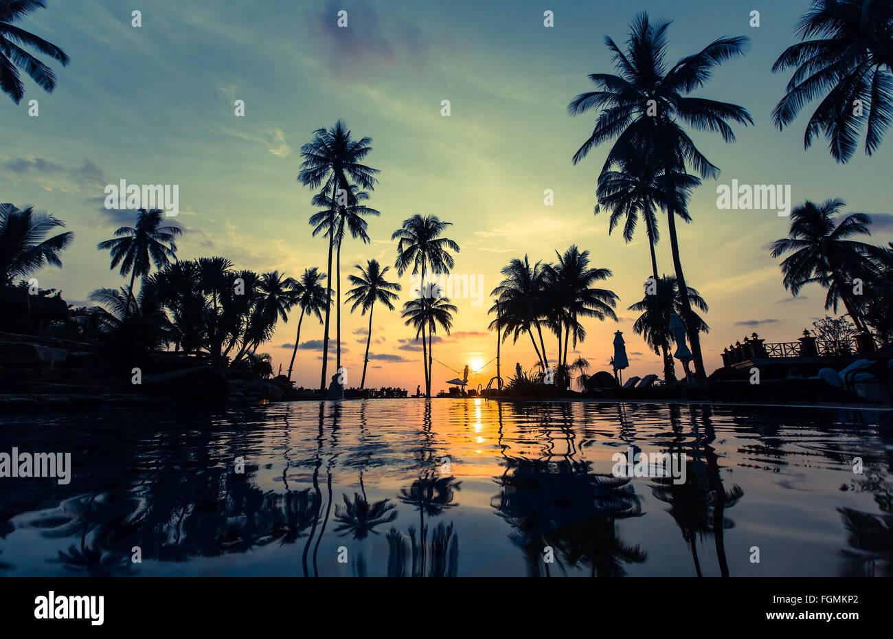 Beautiful sunset on a tropical beach with palm trees reflection in the ...