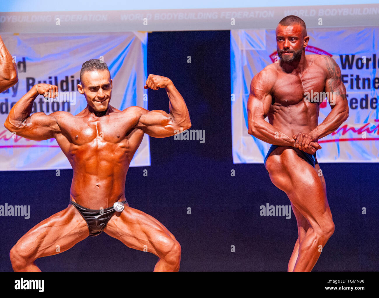 MAASTRICHT, THE NETHERLANDS - OCTOBER 25, 2015: Male bodybuilders Dennis Theys and other competitor flex their muscles Stock Photo
