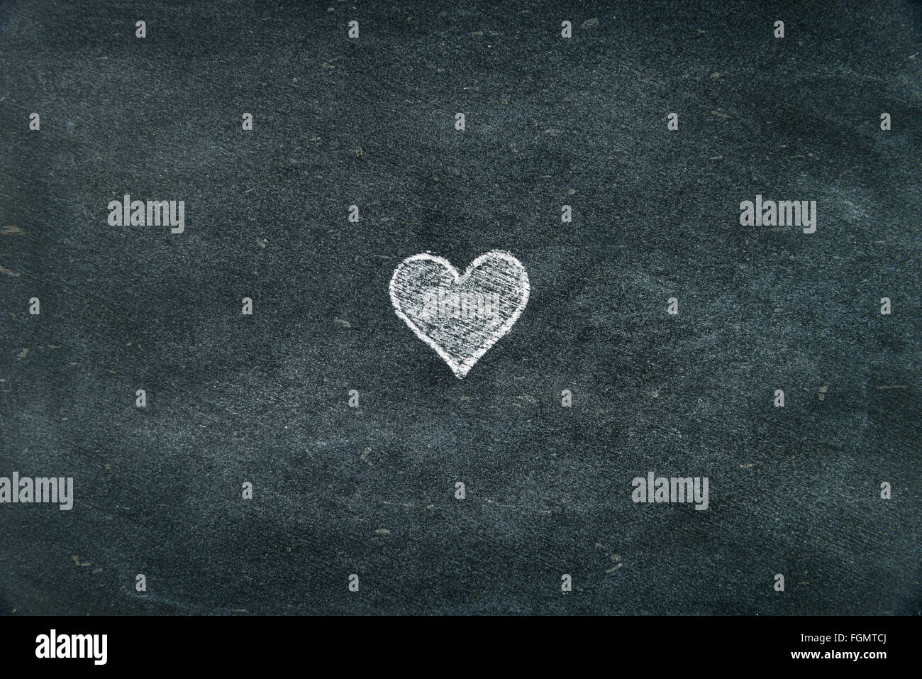 Hand drawing heart shape symbol filled with white on blackboard as ...