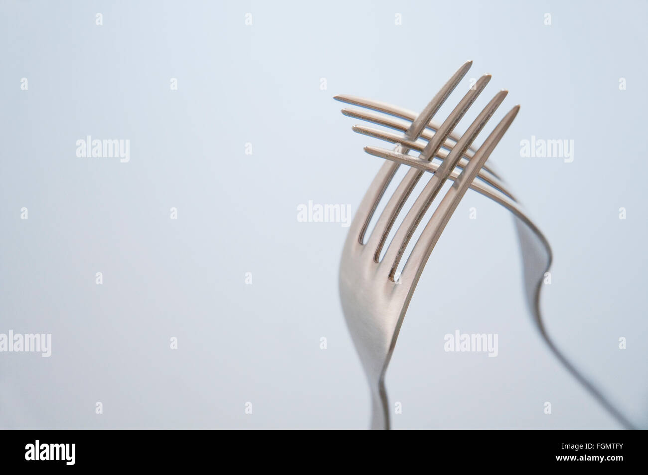 Two interlaced forks. Close view Stock Photo Alamy