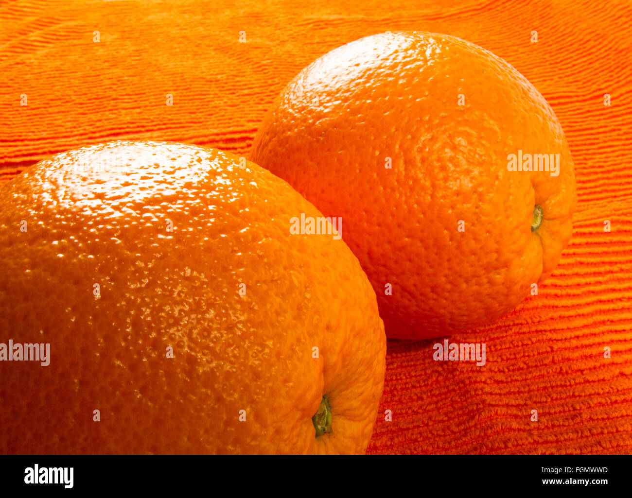 Two Orange on the textile orange background Stock Photo - Alamy