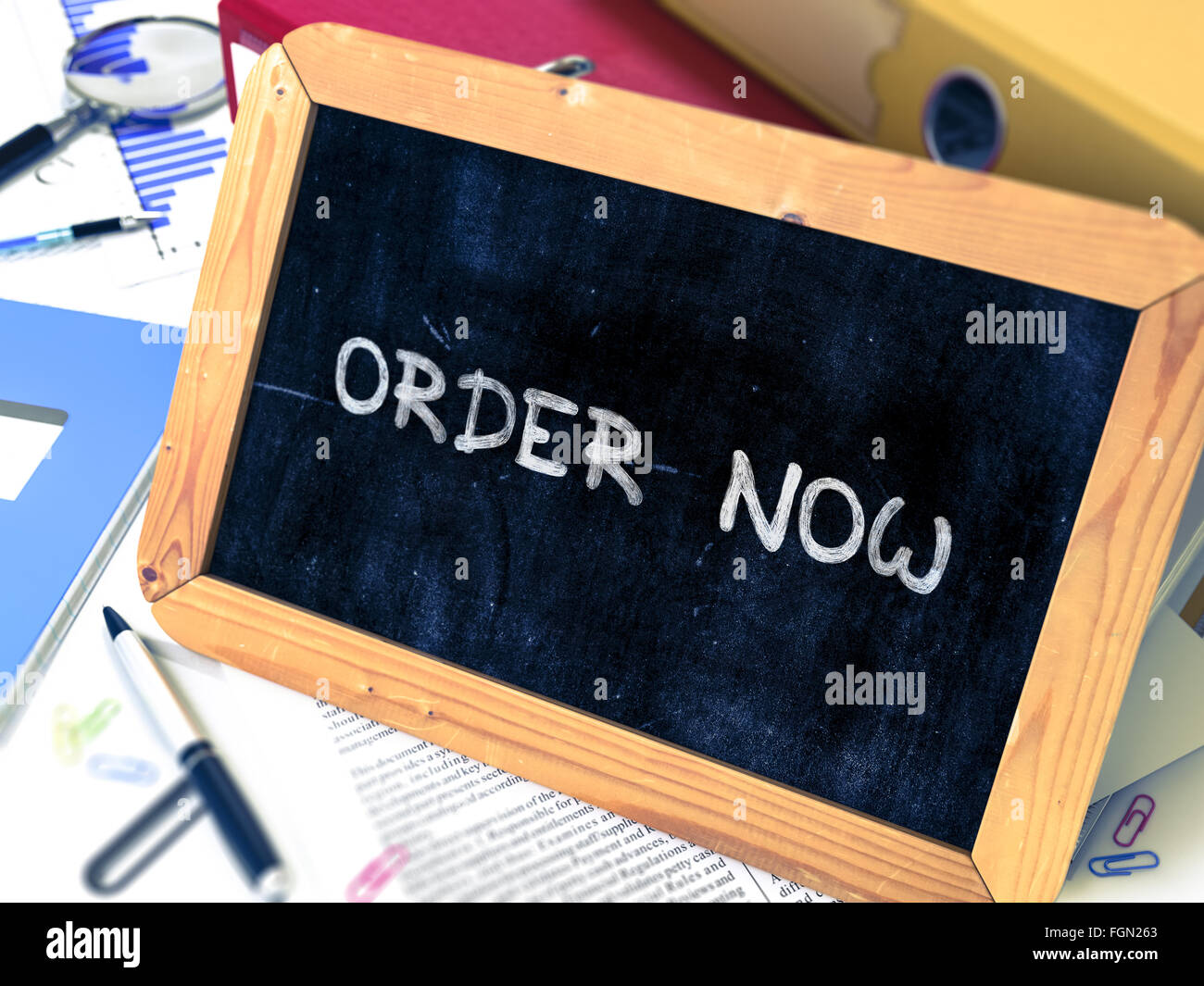 Handwritten Order Now on a Chalkboard. Stock Photo
