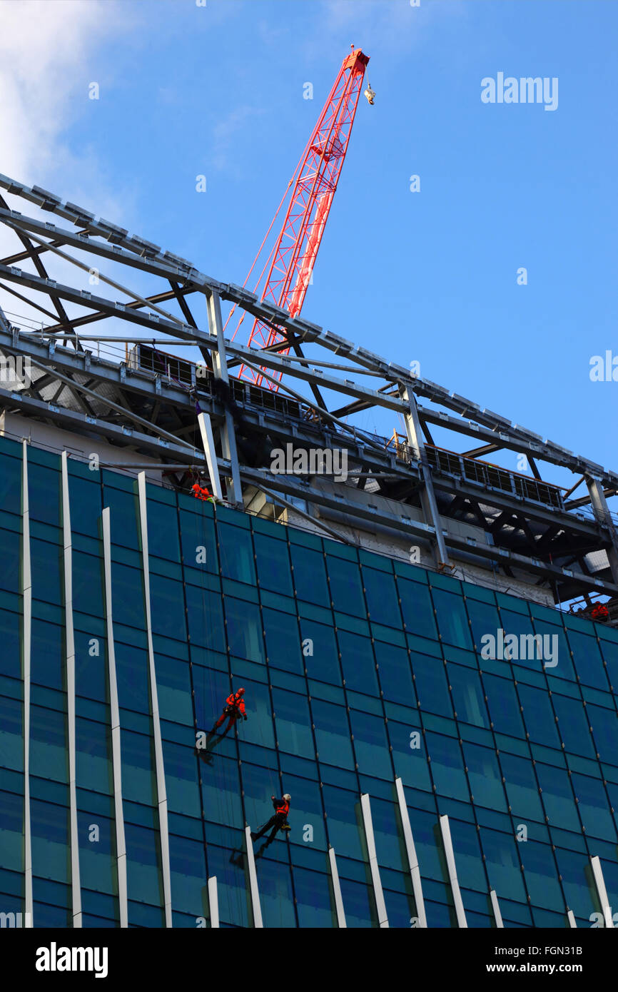 Workers on glass facade of building on Victoria Circle construction site, Victoria, London, England UK Stock Photo