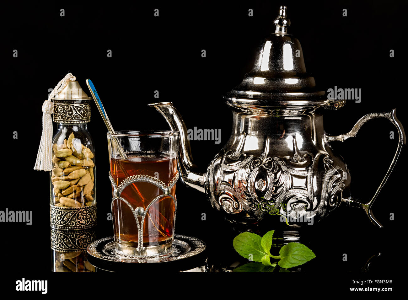 Arabic mint tea and cardamon seeds on the black background Stock Photo