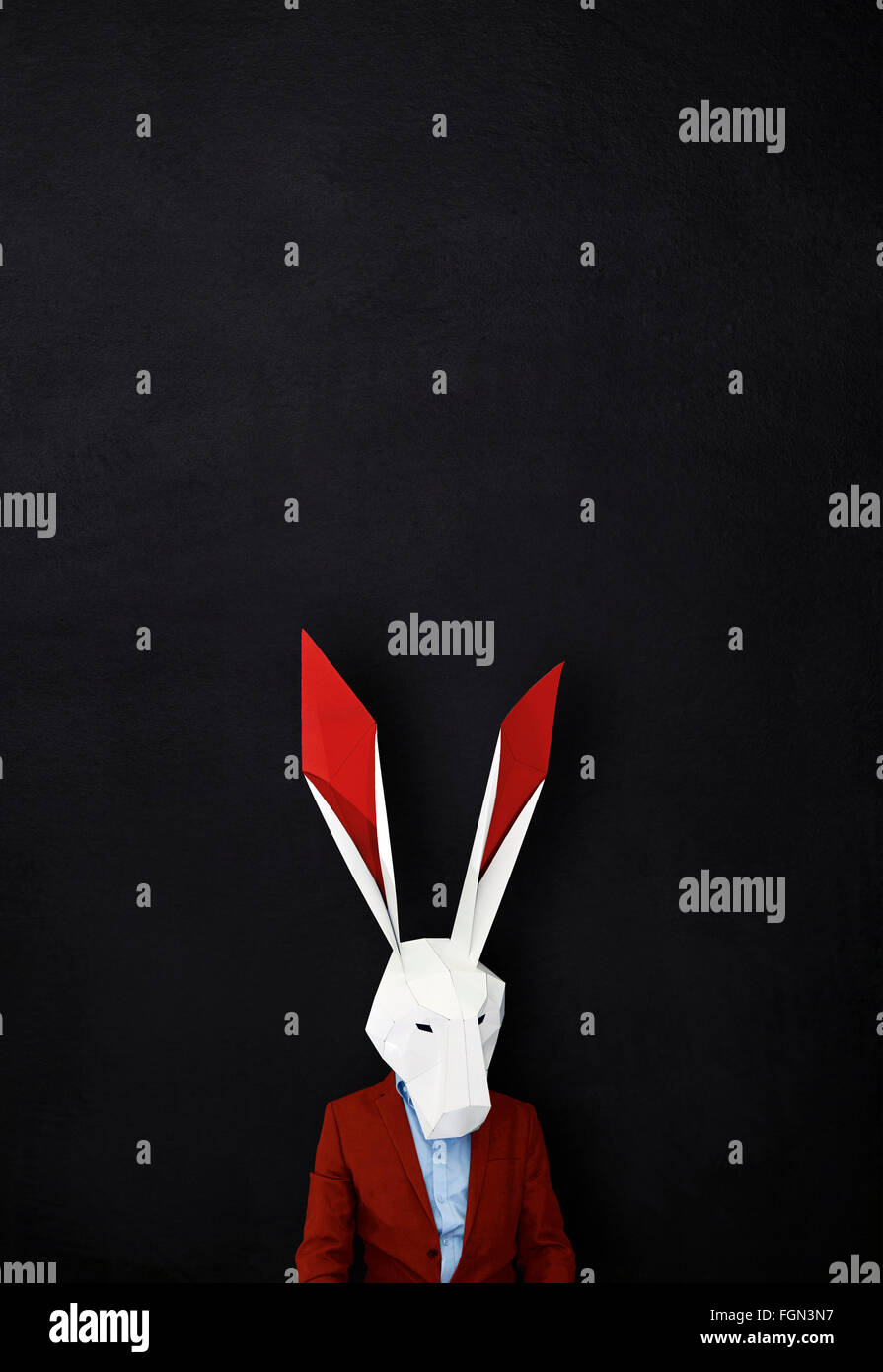 Man in rabbit mask for Valentines day against black background copy ...