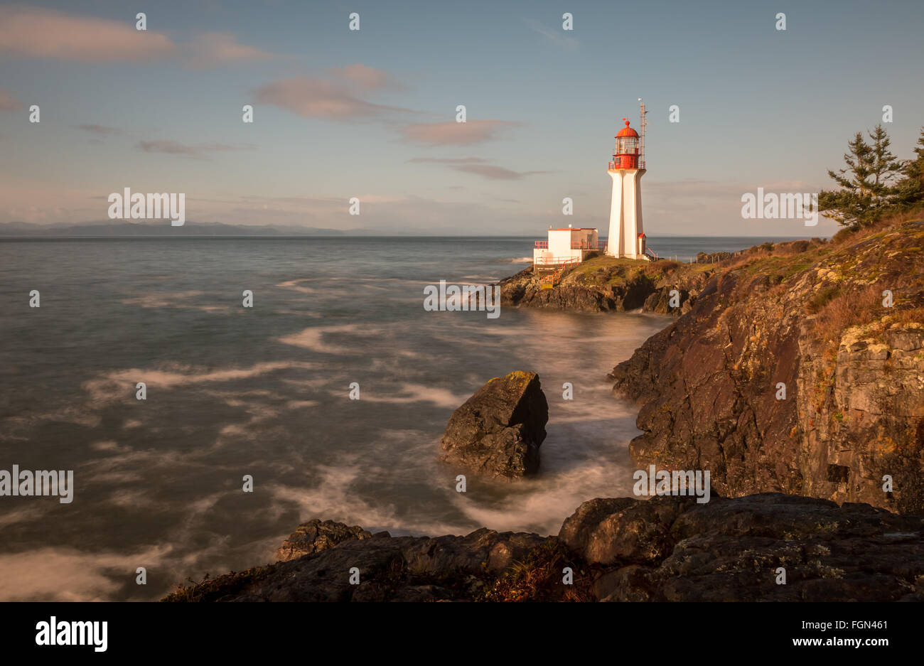 lighthouse on Vancouver Island British Columbia Canada as waves crash onto its rocky shore. Stock Photo
