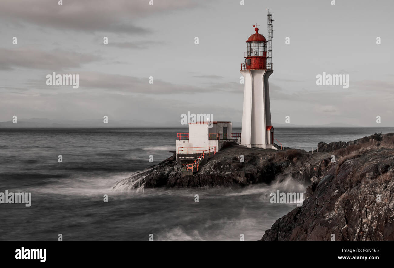 Black and white with contrasting red features and long exposure of a lighthouse  on Vancouver Island British Columbia , Canada. Stock Photo