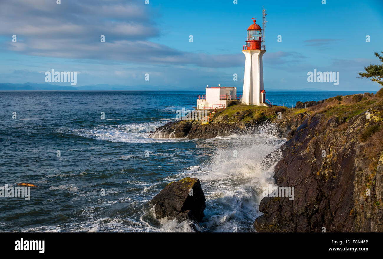 Shearingham Lighthouse on Vancouver Island, British Columbia Canada as waves from the Pacific Ocean roll ashore. Stock Photo
