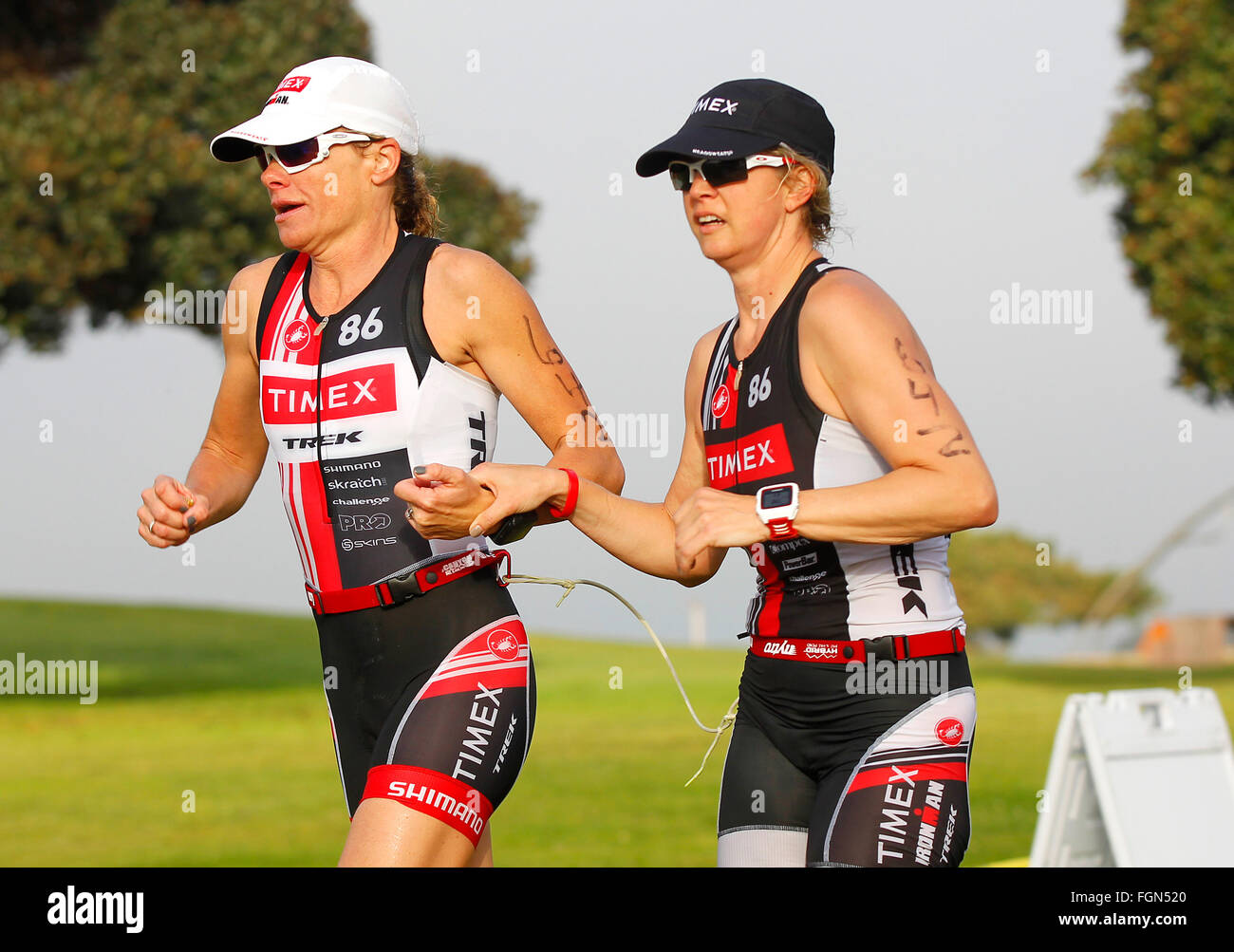 San Diego, California, USA. 21st February, 2016. Susanne Davis, left, and Amy Dixon, a blind triathlete prepare to jump up a curb as they compete in the running portion of the Tritonman triathlon in Mission Bay. | Dixon is training for the Paralympics in Rio de Janeiro and Davis, a world Ironman Champion, is her guide and training partner. This was their first competition training together. (K.C. Alfred/ San Diego Union-Tribune Credit:  K.C. Alfred/U-T San Diego/ZUMA Wire/Alamy Live News Stock Photo