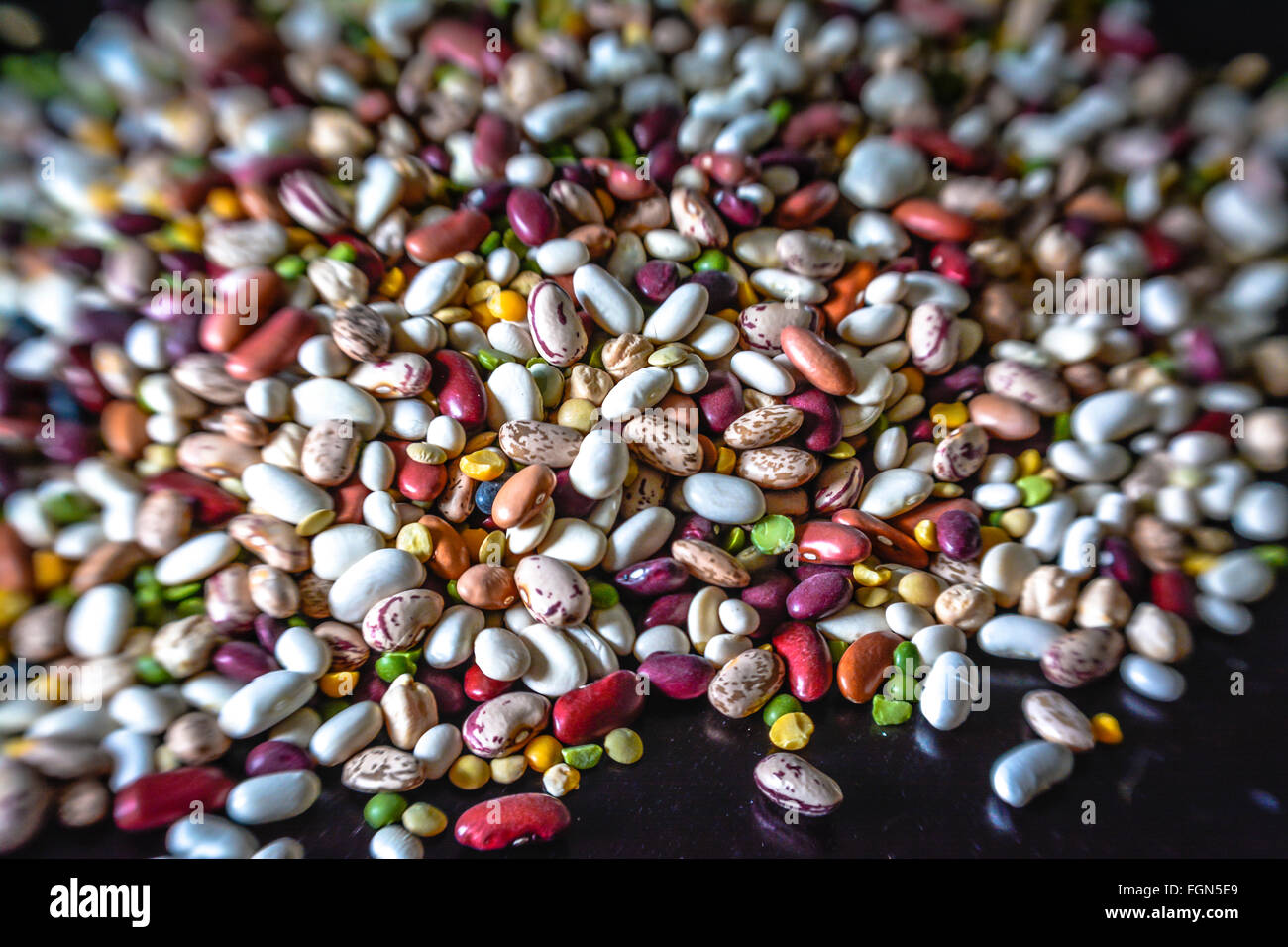 A huge pile of mixed dried beans of all varieties make a colorful