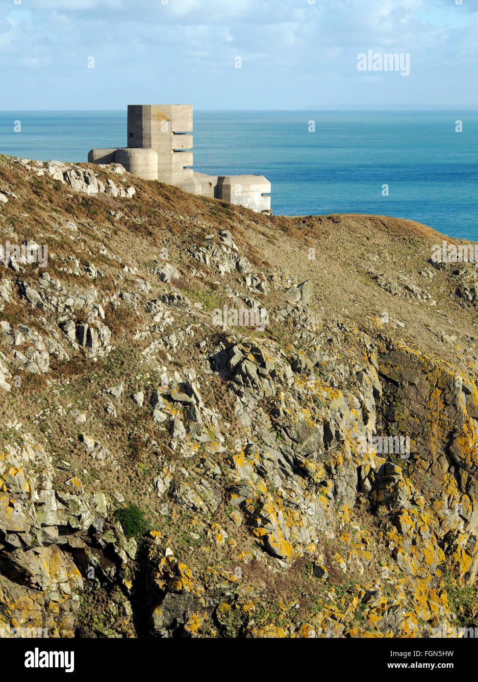 Steep cliffs and WW2 German bunker and observation tower MP4, a relic of occupation, Pleimnont Point, Guernsey, Channel Islands. Stock Photo