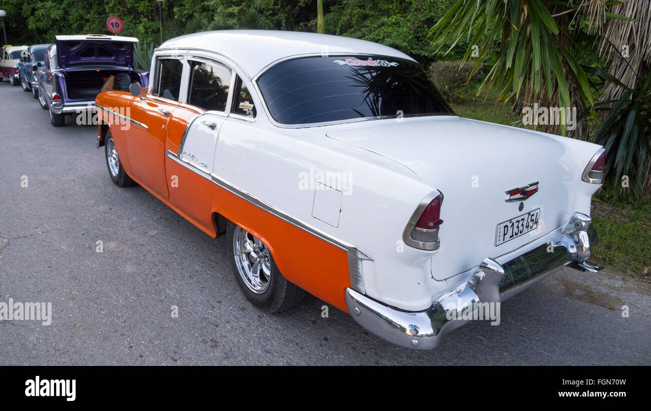 An old 1955 American Chevrolet taxi waiting in a line to pick up tourists outside a resort in Cuba Stock Photo