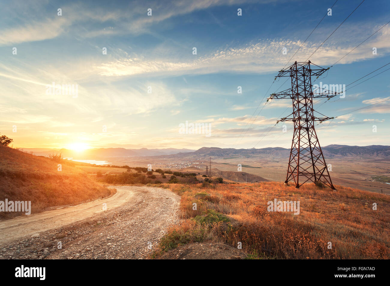 High voltage tower in mountains on the background of colorful sky at ...