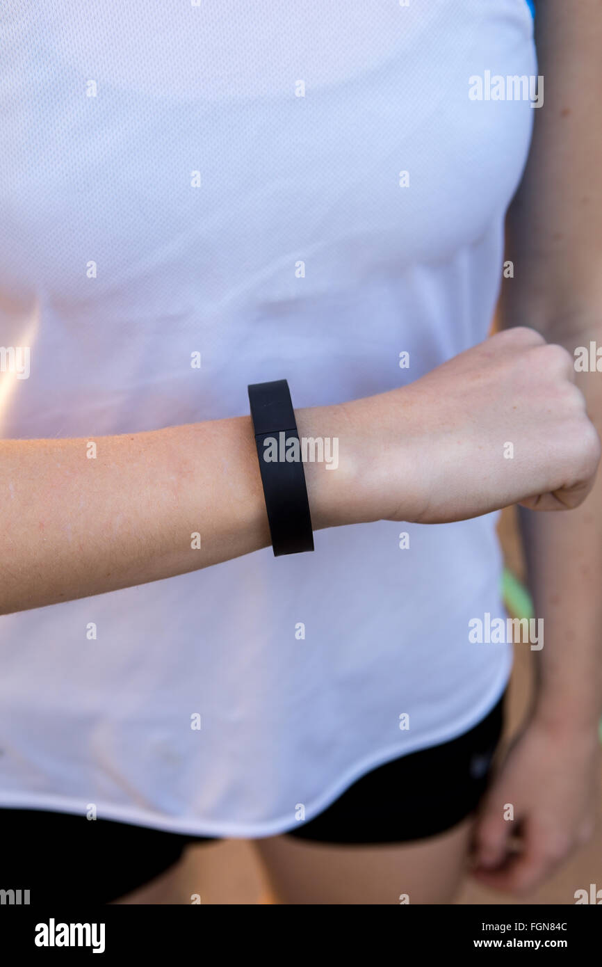 Young woman checks her FitBit  before starting her days exercises Stock Photo