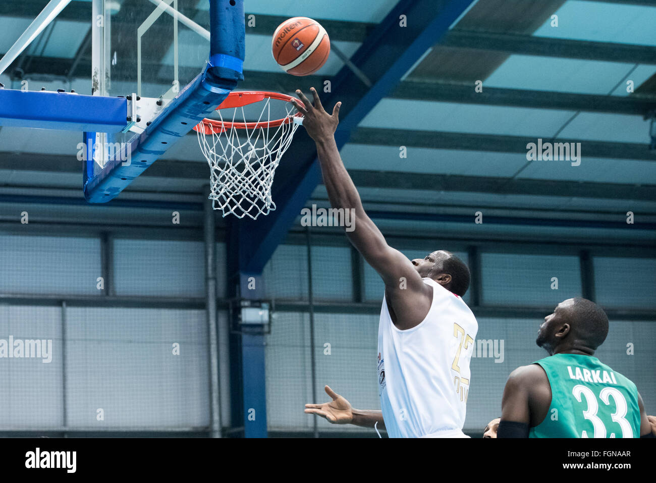 Manchester, England, 21 February 2016. London Lion's vs Manchester Giants at Lucozade Sportsdome. London Lions Olumide Oyedeji (00) shooting a hoop while Manchester Giants Dzaflo Larkai (33) looks on.  Credit:  pmgimaging/Alamy Live News Stock Photo