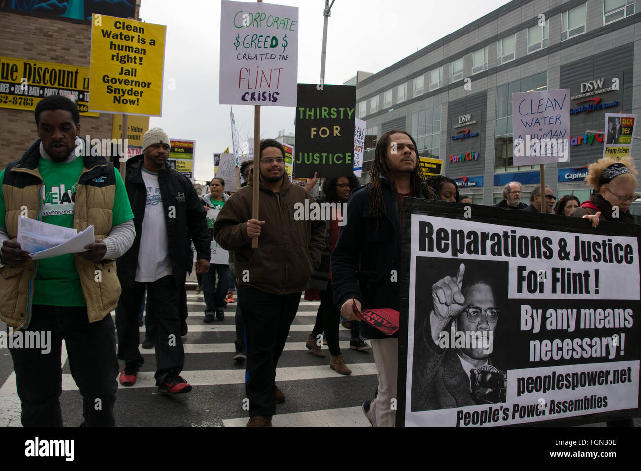 Harlem, New York, USA. 21st February 2016. Social and environmental justice activists march through Harlem after a solidarity rally for Flint, Michigan at the Adam Clayton Powell Jr. State Office Building on the 51st anniversary of the assassination of Malcolm X. Stock Photo