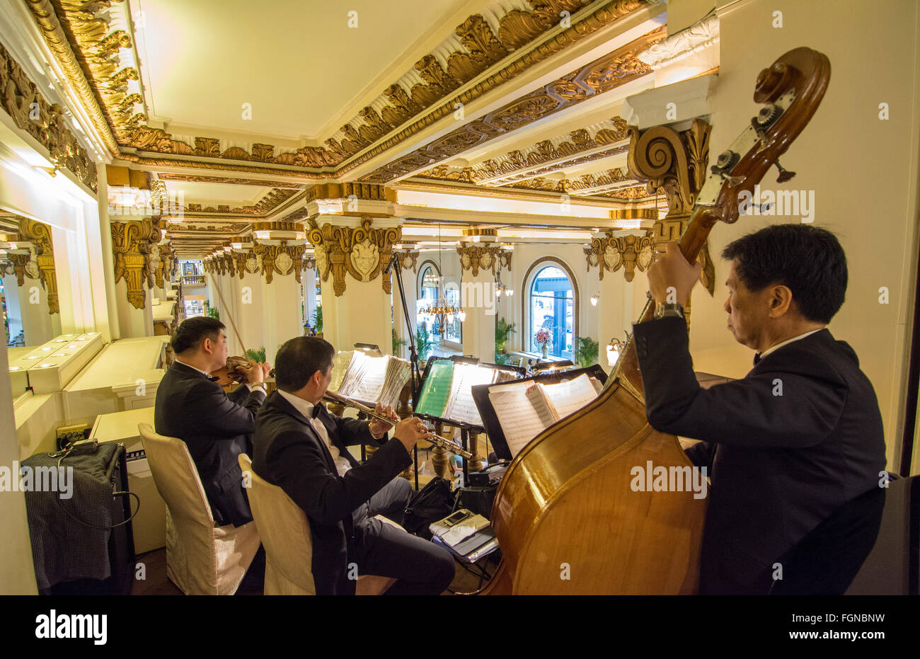 Hong Kong China  Peninsula Hotel orchester playing at high tea in exclusive hotel from above lobby with music Stock Photo