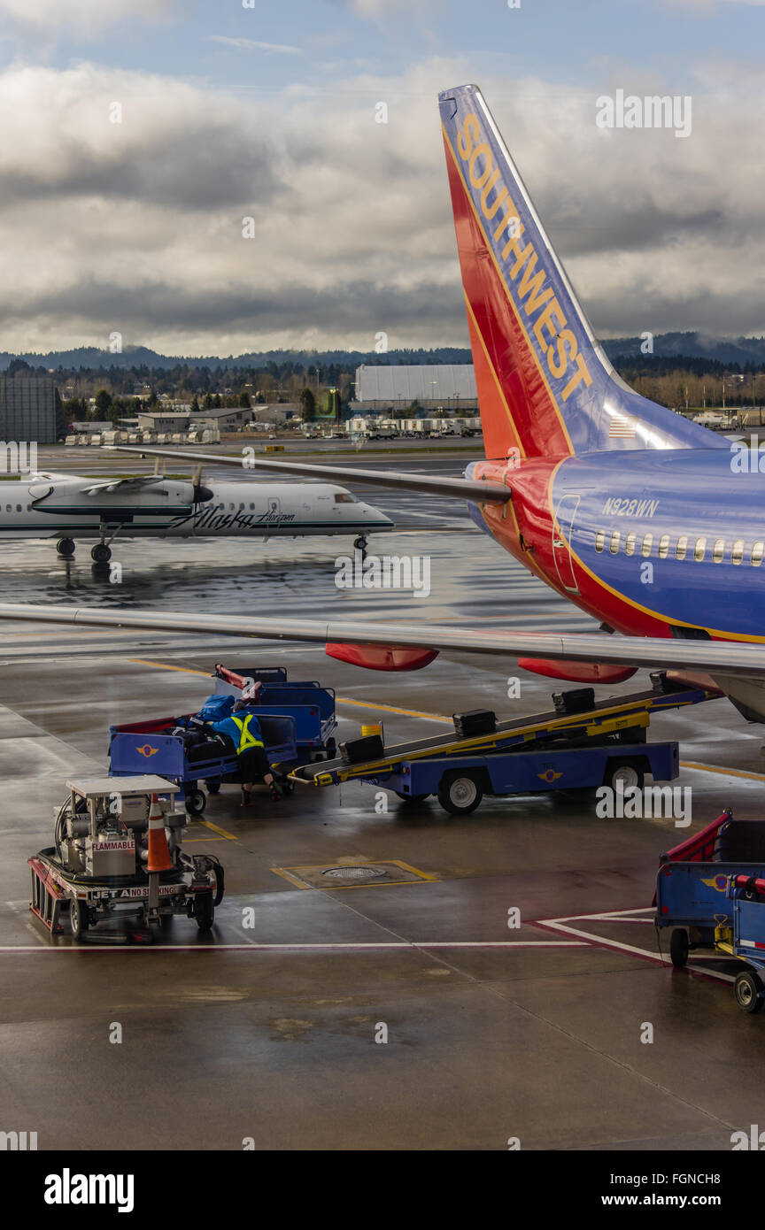 Baggage handler loads luggage aboard a Southwest Airlines flight Stock Photo