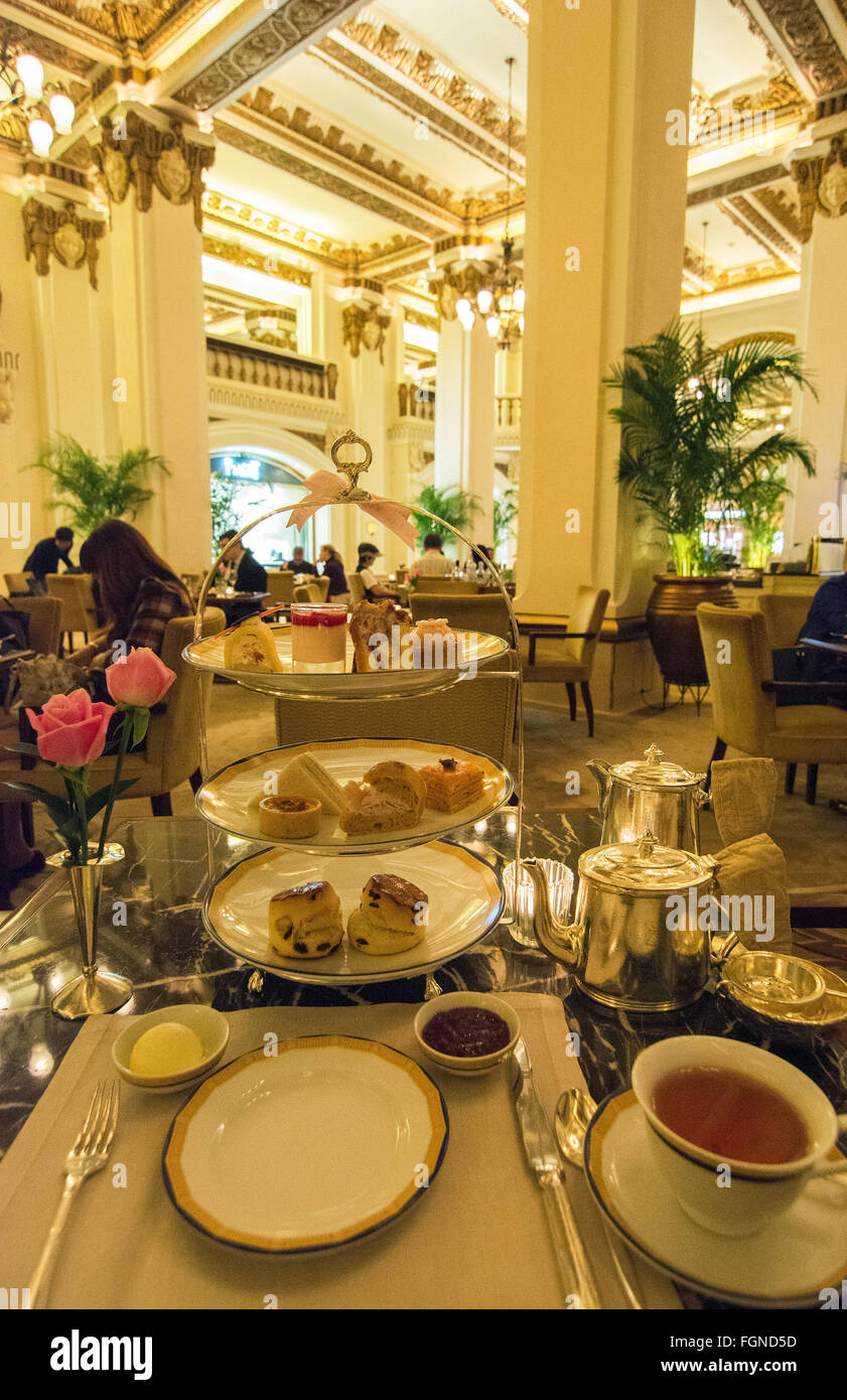 Hong Kong China Peninsula Hotel lobby excclusive High Tea with tea Afternoon Tea of cakes and finger sandwichs at table Stock Photo