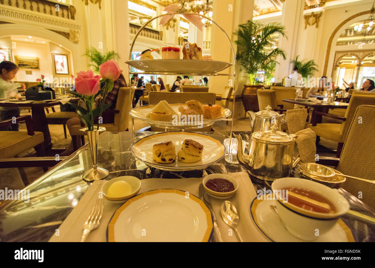 Hong Kong China Peninsula Hotel lobby excclusive High Tea with tea Afternoon Tea of cakes and finger sandwichs at table Stock Photo
