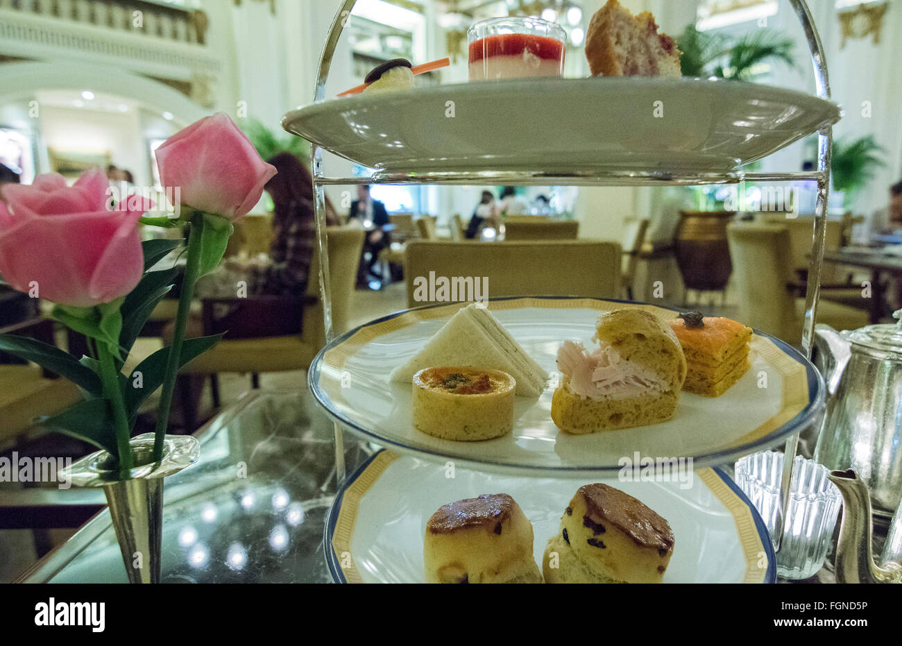 Hong Kong China Peninsula Hotel lobby excclusive High Tea with tea Afternoon Tea of cakes and finger sandwichs at table Stock Photo