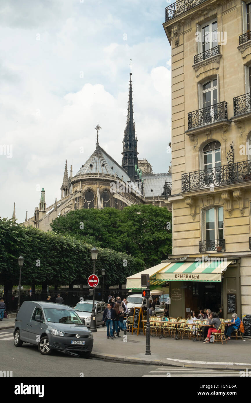 Patrons relax outdoors at the Esmeralda Cafe in Paris, with the Notre-Dame  Cathedral in close view Stock Photo - Alamy