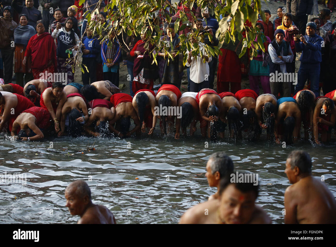 Bhaktapur, Nepal. 22nd Feb, 2016. Nepalese Hindu women devotees bathe after offering prayers on the banks of Hanumante River during the last day of the month-long Swasthani Bratakatha festival, devoted to goddess Shree Swasthani and Lord Madhav Narayan in Bhaktapur, Nepal on Monday, February 22, 16. Men devotees recite Holy Scripture and women pray for wellbeing of their spouses throughout the month-long fast via travelling barefooted to holy shrines for worship. Credit:  Skanda Gautam/ZUMA Wire/Alamy Live News Stock Photo