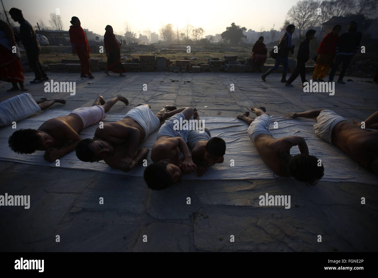 Bhaktapur, Nepal. 22nd Feb, 2016. Nepalese Hindu devotees roll on the ground while offering prayers during the last day of the month-long Swasthani Bratakatha festival, devoted to goddess Shree Swasthani and Lord Madhav Narayan in Bhaktapur, Nepal on Monday, February 22, 16. Men devotees recite Holy Scripture and women pray for wellbeing of their spouses throughout the month-long fast via travelling barefooted to holy shrines for worship. Credit:  Skanda Gautam/ZUMA Wire/Alamy Live News Stock Photo