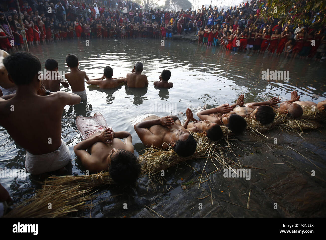 Bhaktapur, Nepal. 22nd Feb, 2016. Nepalese Hindu devotees offer prayers on the banks of Hanumante River during the last day of the month-long Swasthani Bratakatha festival, devoted to goddess Shree Swasthani and Lord Madhav Narayan in Bhaktapur, Nepal on Monday, February 22, 16. Men devotees recite Holy Scripture and women pray for wellbeing of their spouses throughout the month-long fast via travelling barefooted to holy shrines for worship. Credit:  Skanda Gautam/ZUMA Wire/Alamy Live News Stock Photo