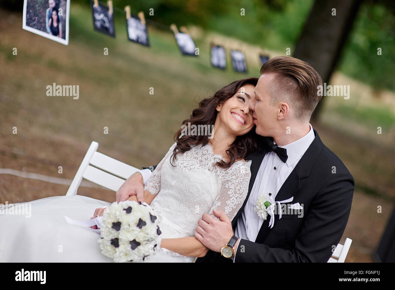 Happy bride and groom sitting on bench in the park Stock Photo - Alamy