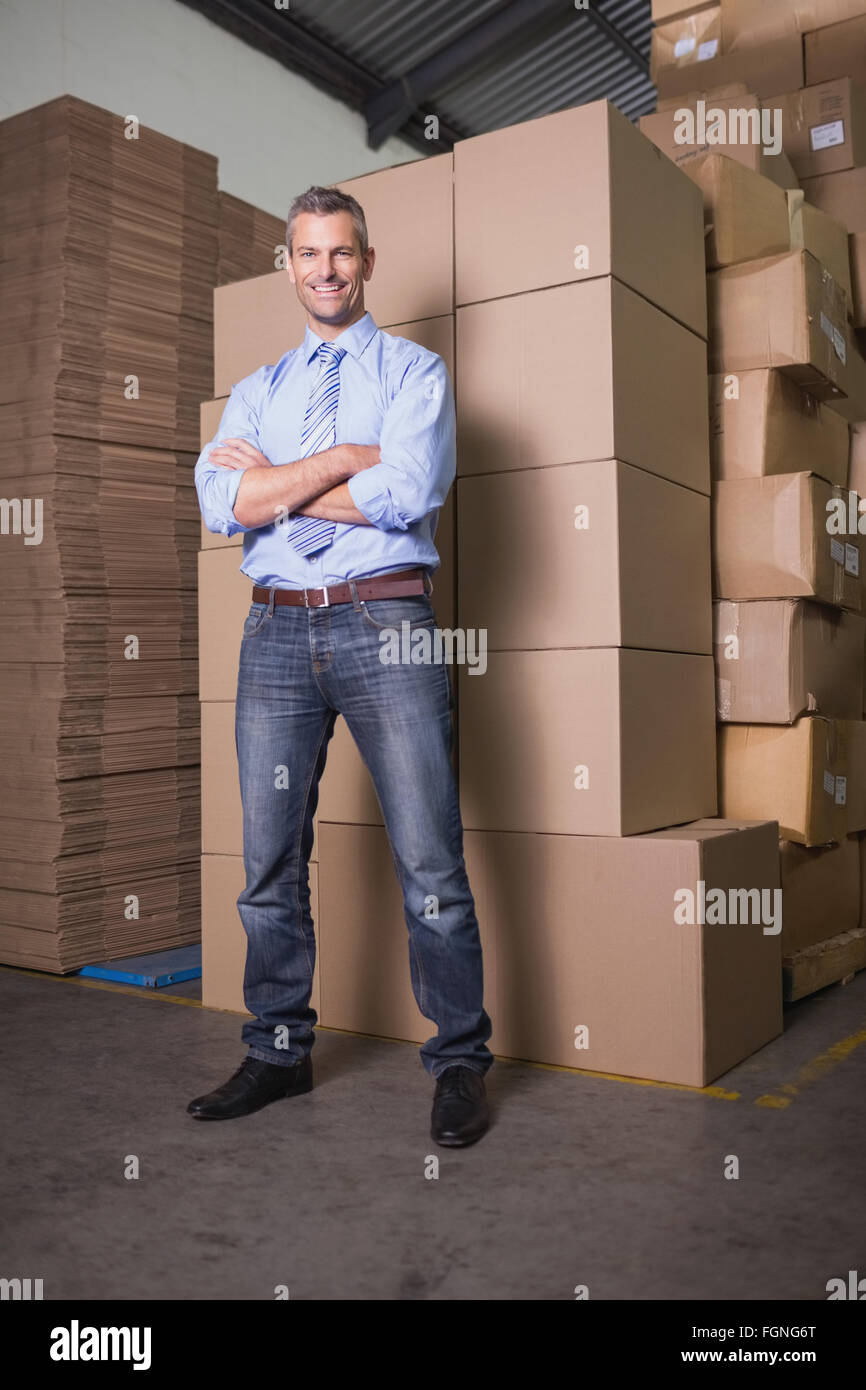 Smiling manager with arms crossed in warehouse Stock Photo - Alamy
