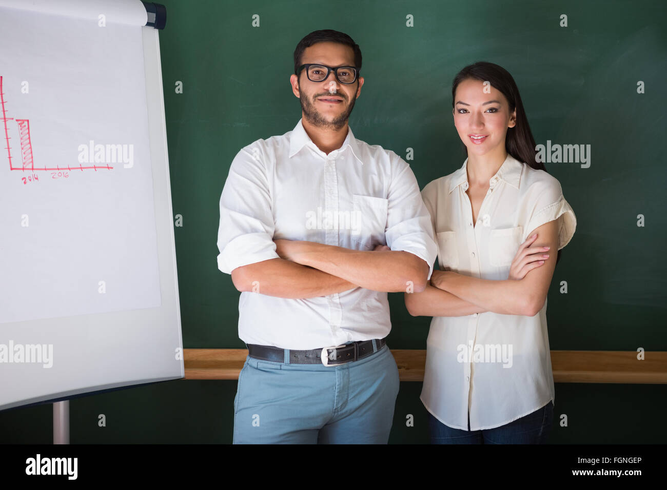 Two confident business people with arms crossed in office Stock Photo ...