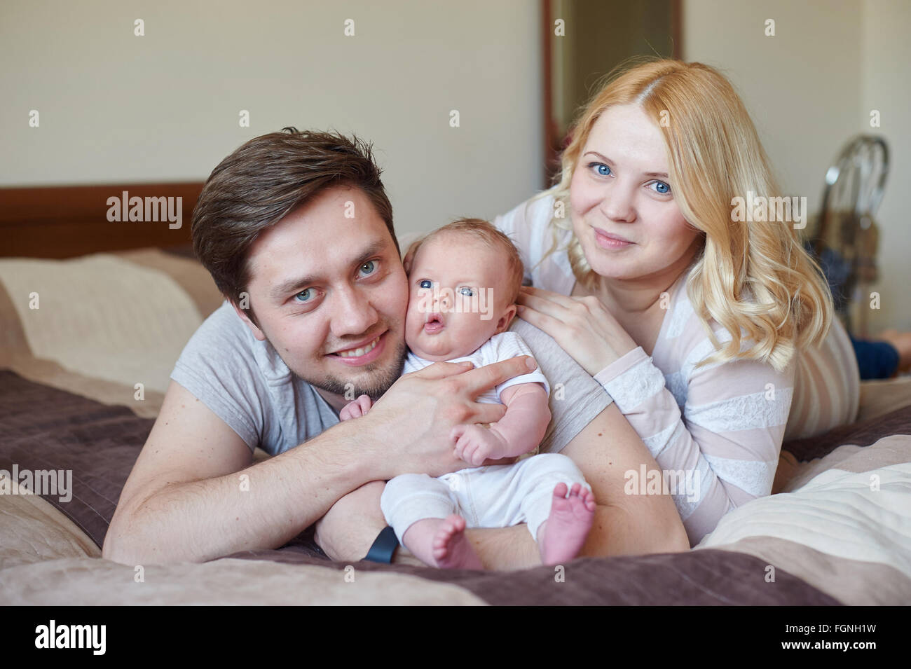 Happy Young Attractive Family parents with Newborn Baby Stock Photo