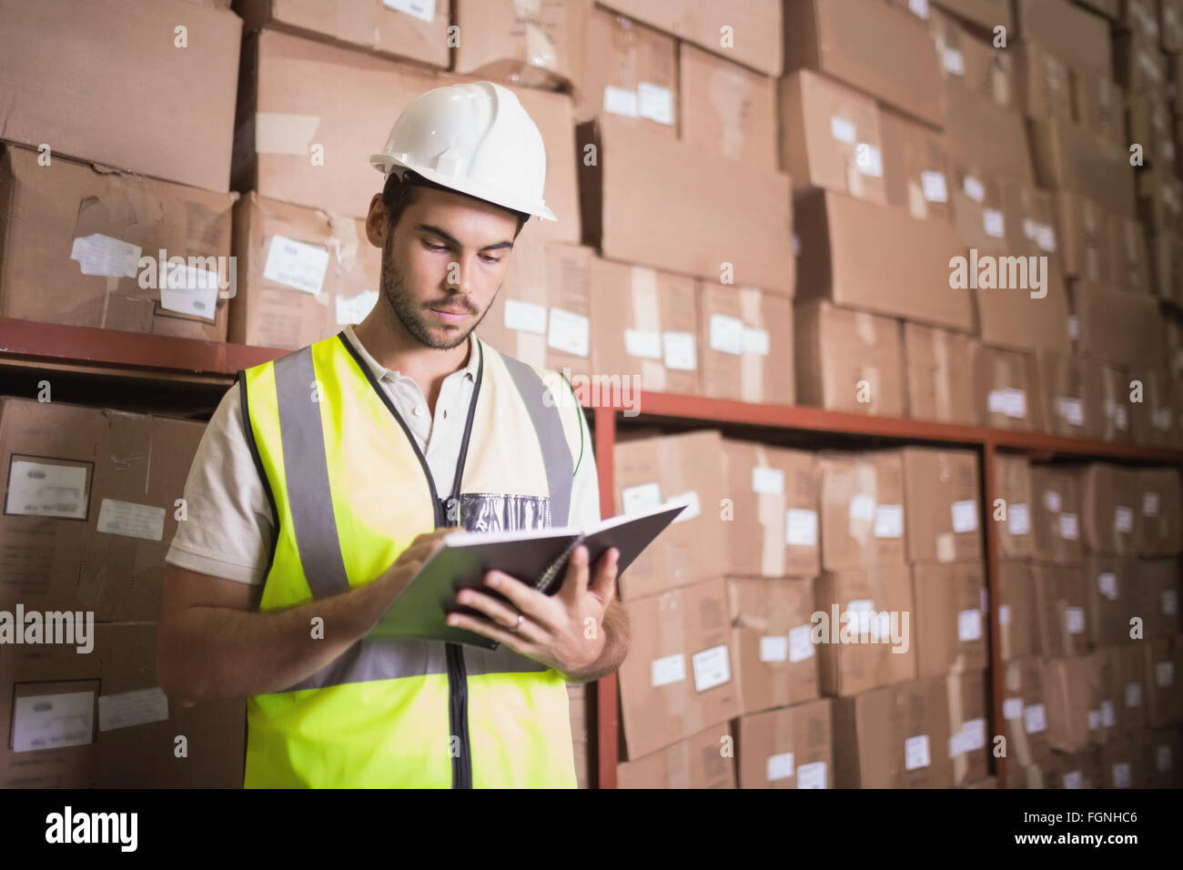 Worker with diary in warehouse Stock Photo