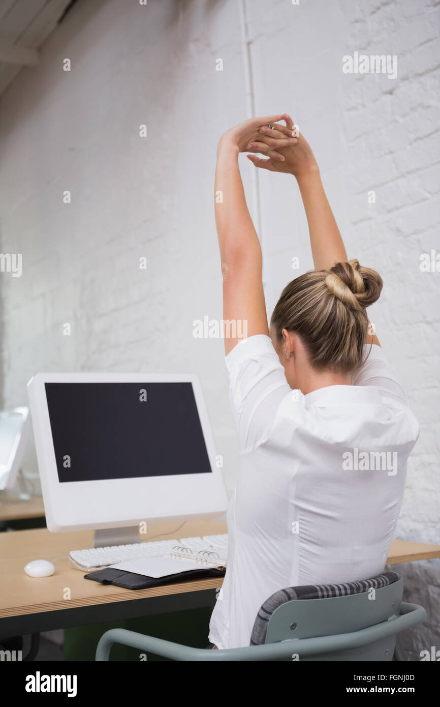 Businesswoman stretching hands in front of computer Stock Photo - Alamy