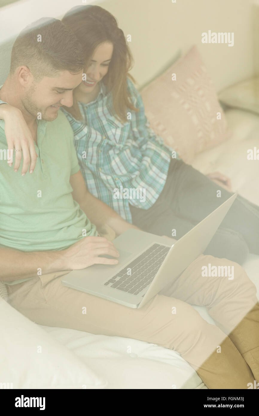Cute couple relaxing on couch with laptop Stock Photo - Alamy